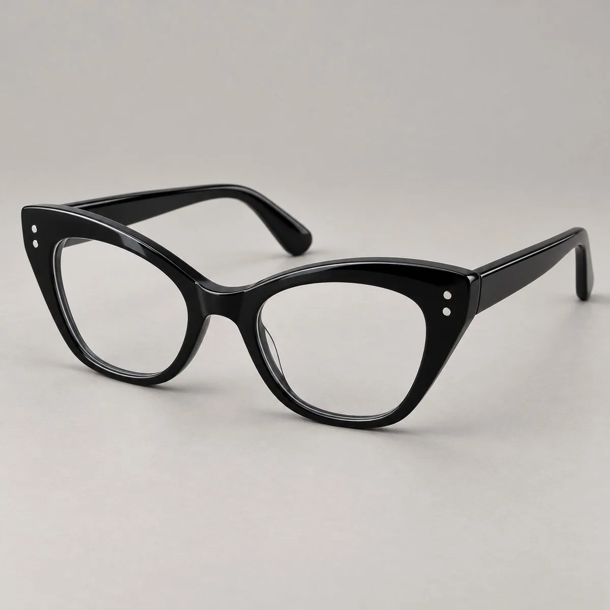 Occhiale cat-eye deciso in acetato nero lucido con piccoli rivetti metallici Occhiale cat-eye deciso in acetato nero lucido con piccoli rivetti metallici