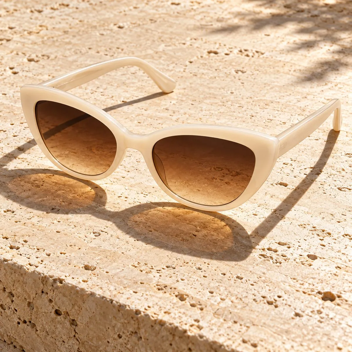Occhiali da sole cat-eye avorio con lenti sfumate marroni al sole Occhiali da sole cat-eye avorio con lenti sfumate marroni al sole